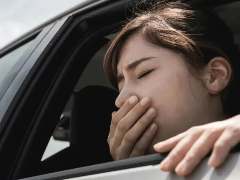 車内で焦げ臭さやオイル臭に気づき不調を訴える女性ドライバー